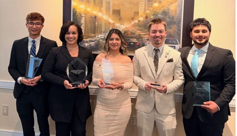 Five Relentless Marketing team members holding awards at a client recognition event