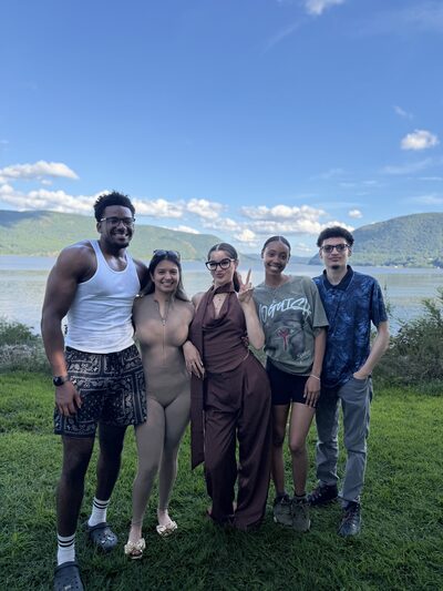 Five team members together on the riverbank at a summer team outing