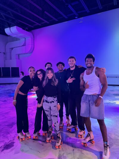 Team members together on the floor of a roller skating rink